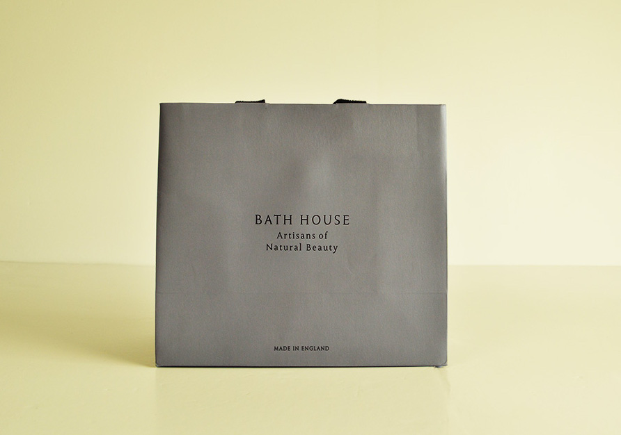 Grey custom printed ribbon handle paper bag on yellow background