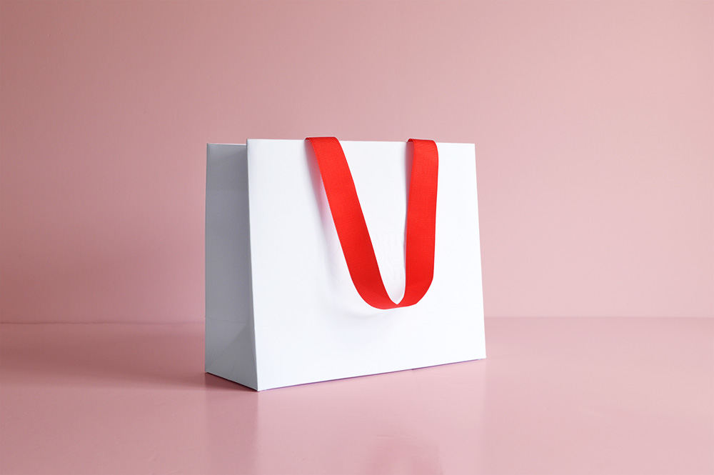 White custom printed paper bag with red ribbon handles