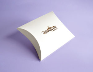 white custom made pillow box with gold logo on purple background