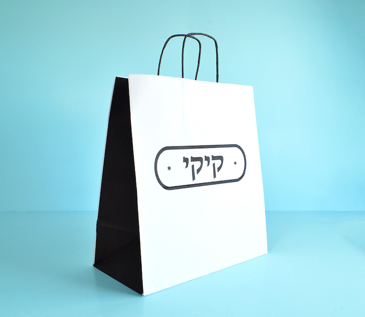 custom printed white twisted handle paper bag on blue background